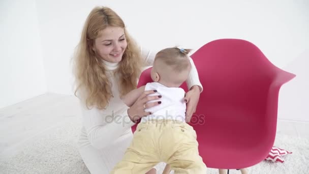 Joven madre jugando con su bebé en la silla — Vídeos de Stock