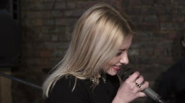 Güzel kadının mikrofon şarkı closeup