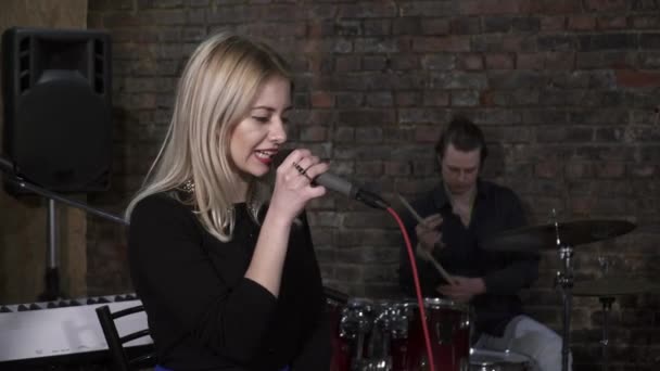 Молодая женщина поет под микрофон на репетиции — стоковое видео