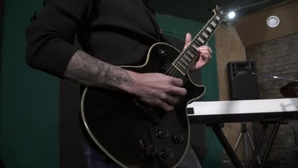 Close-up van mans hand gitaar te spelen op de repetitie — Stockvideo