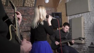 Güzel sarışın kadının rock grubunda şarkı