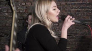 Genç kadının rock grubu prova üzerinde şarkı