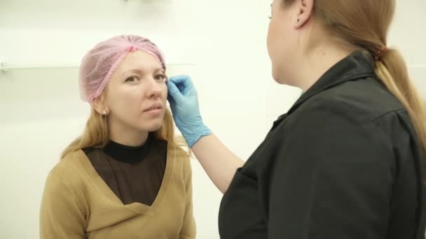 Cosmetolog pregătește o femeie tânără pentru procedura permanentă de machiaj — Videoclip de stoc