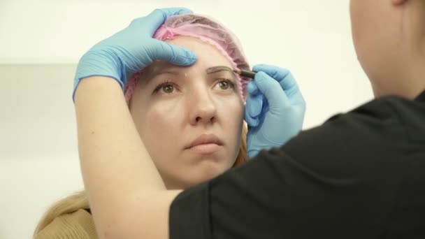 Cosmetólogo preparando a la mujer para el primer plano de maquillaje permanente — Vídeo de stock