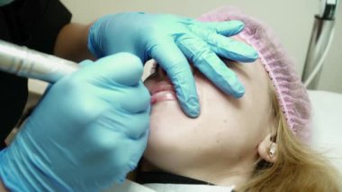 Güzellik uzmanı genç kadının dudakları kalıcı makyaj ile doldurma