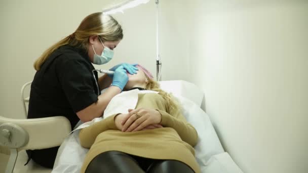 Cosmetologist is making the permanent makeup in salon — Stock Video