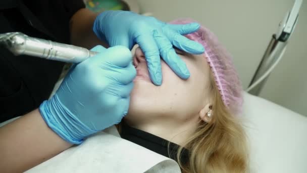 Kosmetolog är att göra den permanent makeupen för en ung kvinna — Stockvideo