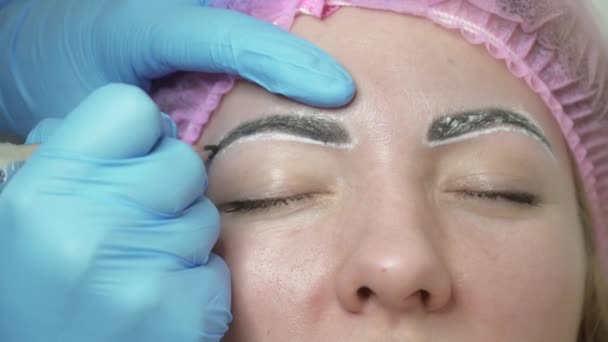 Schoonheidsspecialist is het maken van een close-up van de permanente make-up wenkbrauwen — Stockvideo