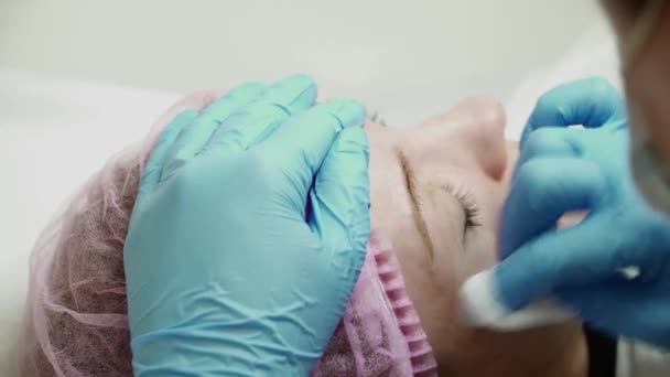 Kosmetolog är att göra en permanent makeup ögonbryn — Stockvideo