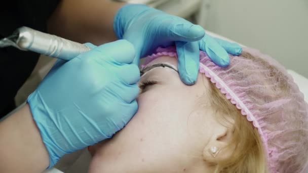Косметик делает брови постоянным макияжем в салоне крупным планом — стоковое видео