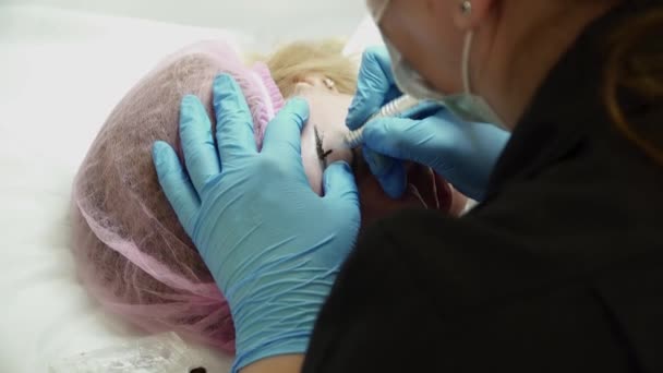 Schoonheidsspecialiste is het maken van een wenkbrauw permanente make-up voor een vrouw — Stockvideo