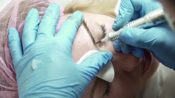 El primer plano del esteticista está haciendo un maquillaje permanente de la ceja en salón de belleza — Vídeos de Stock