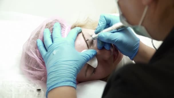 Closeup αισθητικός κάνει ένα φρύδι μόνιμη μακιγιάζ για μια γυναίκα — Αρχείο Βίντεο