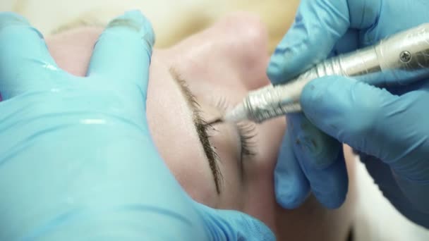 Primo piano del cosmetologo sta facendo un trucco permanente del sopracciglio nel salone — Video Stock