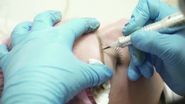 Närbild av kosmetolog är att göra en permanent makeup ögonbryn i salong närbild — Stockvideo