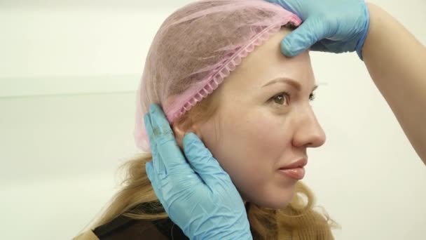 Cosmetologist is checking her permanent makeup done — Stock Video