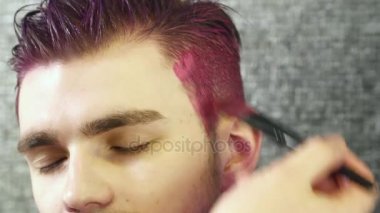 Genç boyama makyaj sanatçısı pembe saç adamın