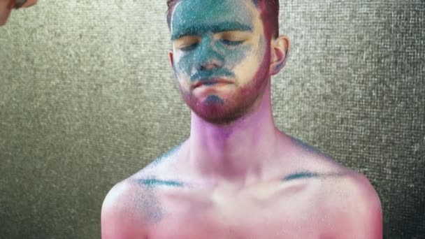 Makeup artist covering young mans body with the paint — Stock Video