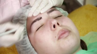 Güzellik uzmanı bir kadın için microblading yordam yapıyor
