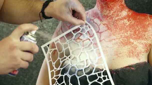 Creazione di body art sul petto delle donne con l'aiuto di uno stencil — Video Stock