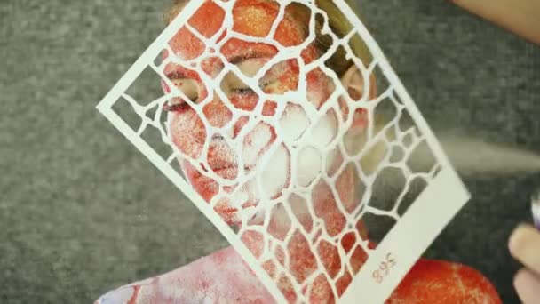 Att skapa kroppskonst på kvinnans ansikte med hjälp av en stencil — Stockvideo