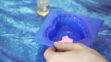 Mavi kalp şablonuna el yapımı sabun oluşturmak için dökme sabun temel WOMANS eller