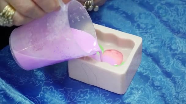 Hands pouring the colored soap base to the template — Stock Video