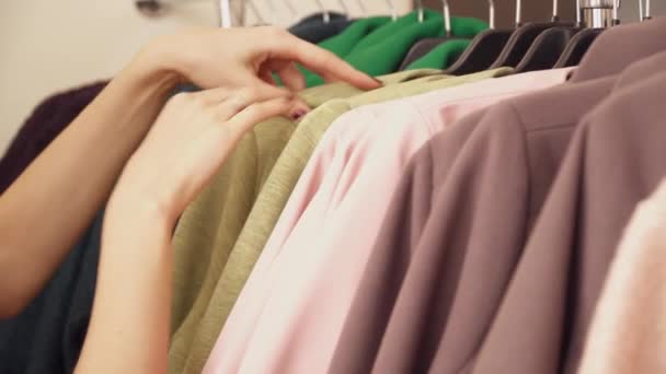 Крупним планом жіночі руки вибираючи пальто — стокове відео