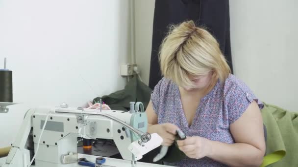 Blonde vrouw bezig met de fabriek kleding naaien — Stockvideo