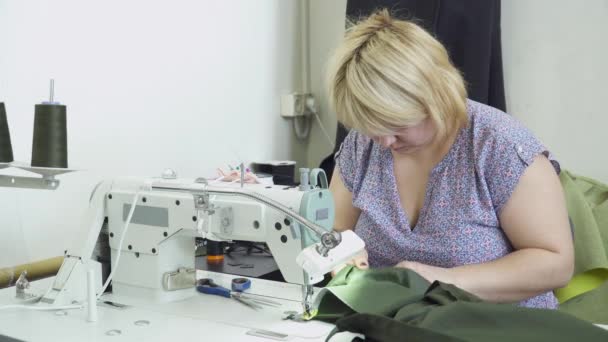 Женщина создает платье на швейной фабрике — стоковое видео