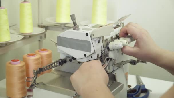 Женщина регулирует швейную машинку крупным планом — стоковое видео