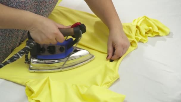 Donna stiratura il vestito giallo primo piano rallentatore — Video Stock