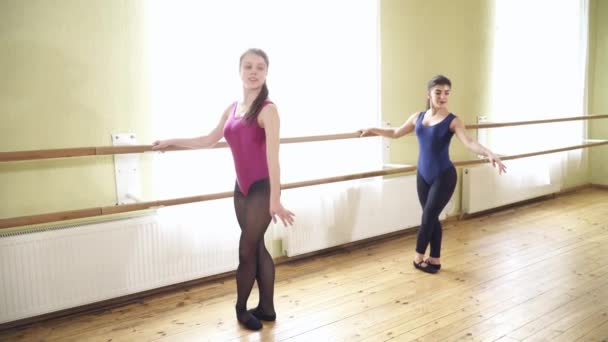 Tiener meisjes springen in de dansende studio in de buurt van de barre — Stockvideo