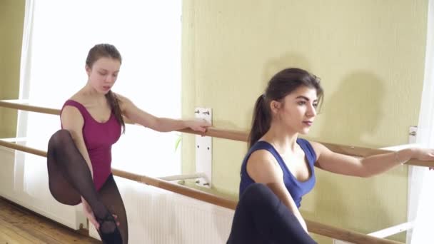 Två tonåring flickor stretching nära barre närbild — Stockvideo