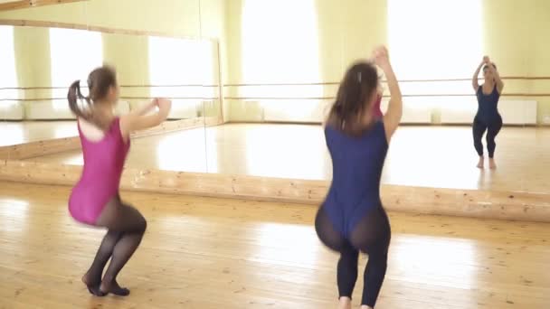 Девочки-подростки танцуют современный танец перед зеркалом — стоковое видео
