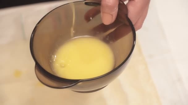 Mujeres manos revolviendo los huevos en el tazón — Vídeo de stock