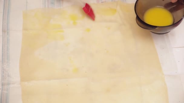 Zenske ruce šíření zamíchat vejce přes těsto — Stock video