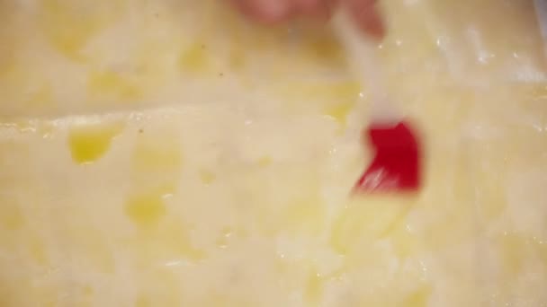 Γυναικεία χέρια εξαπλώνεται το ανακατεμένο αυγά μέσα από το closeup ζύμη — Αρχείο Βίντεο