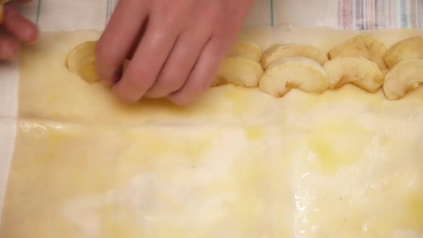 Femmes mains mettre des pommes coupées à la pâte gros plan — Video