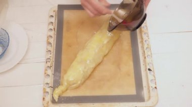 Kadının kapsayan ham strudel Damlama Pan karıştırılmış yumurta ile eller