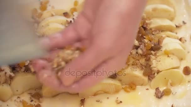 Женские руки добавляют орехи в яблоки крупным планом. — стоковое видео