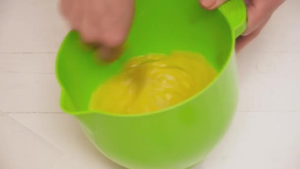 Женские руки, перемешивающие яйца в зеленой чаше — стоковое видео