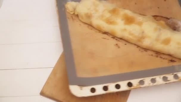 Mãos femininas colocando strudel quente fresco no tabuleiro de madeira — Vídeo de Stock