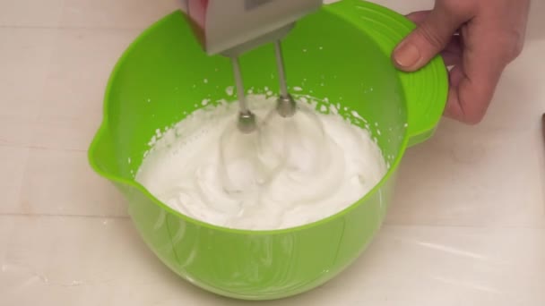 Close-up van vrouw melk mengen met de eieren in de kom slow motion — Stockvideo