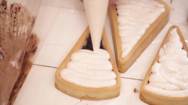 Weiße Sahne zu den kleinen Torten mit Chokolate Nahaufnahme hinzufügen — Stockvideo