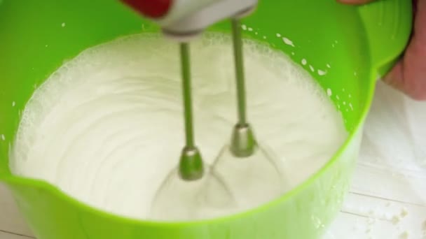 Femmes mains prepering la crème pour les éclairs avec mélangeur 