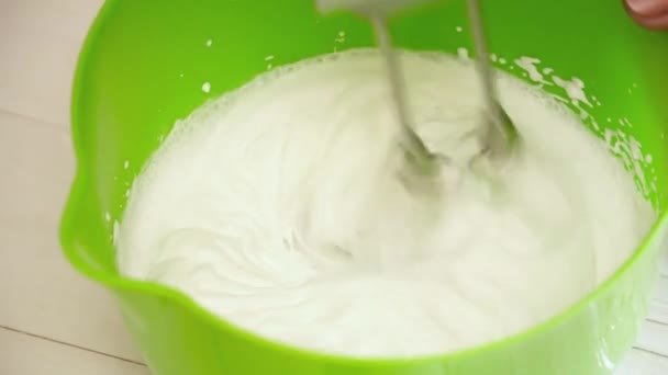 Frauenhände bereiten die Creme mit dem Mixer vor — Stockvideo