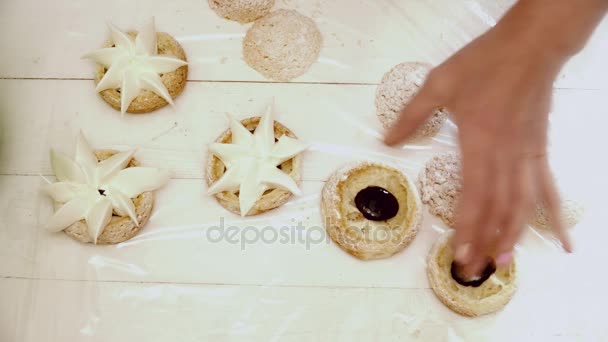 Ręce dodając krem dekoracja do ciastko — Wideo stockowe