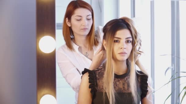 Στυλίστας μαλλιά δημιουργώντας ένα χτένισμα στο κομμωτήριο — Αρχείο Βίντεο