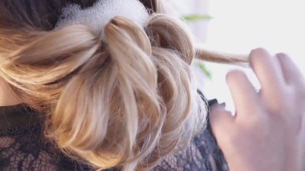 Στυλίστας μαλλιά δημιουργώντας ένα χτένισμα για μια νεαρή γυναίκα στο σαλόνι — Αρχείο Βίντεο